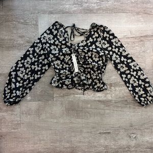 Beautiful black top with a floral pattern. Size medium and never worn.